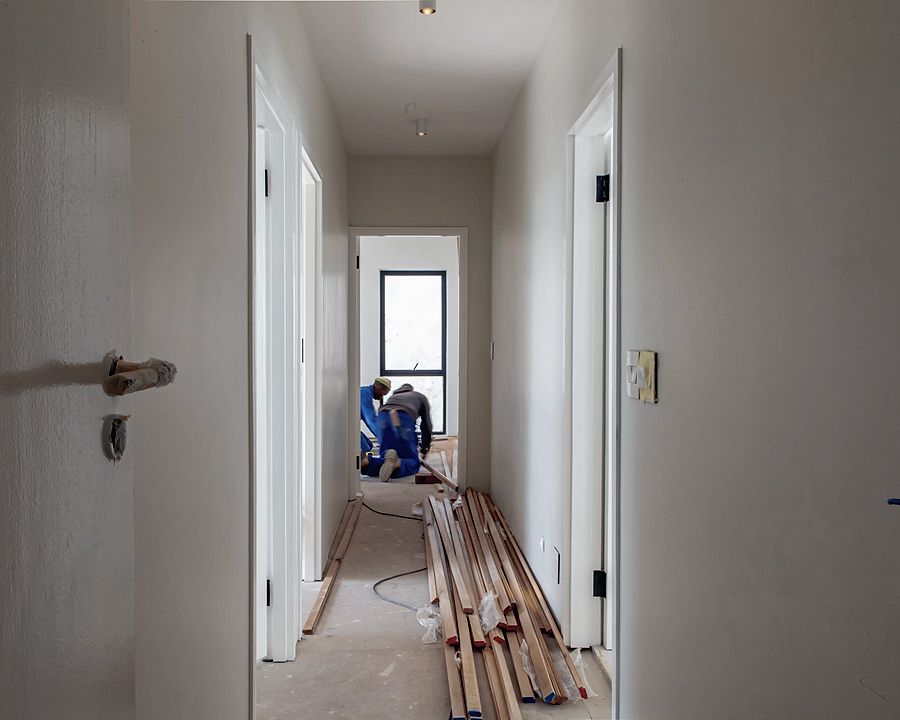 The same corridor rebuilt — ceiling closed, walls painted, new doors hung
