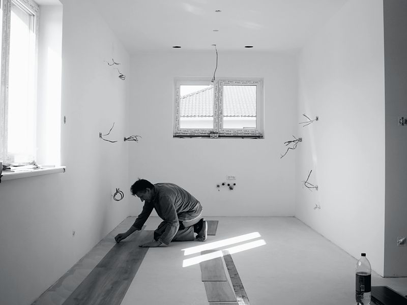 A unit mid-make-ready with open wiring and flooring part-laid