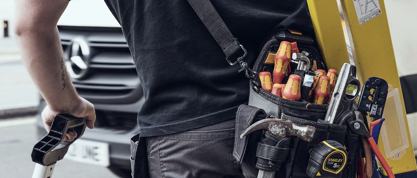 Tradesperson with a tool belt loading up for a scheduled work order