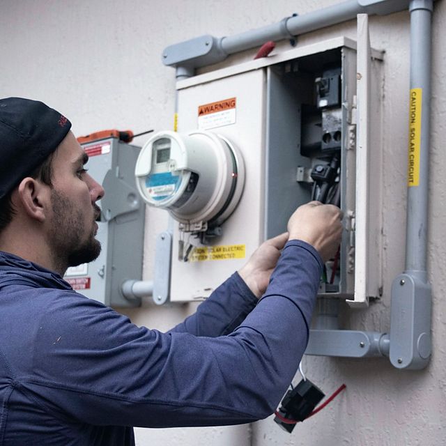 Technician servicing an electrical panel