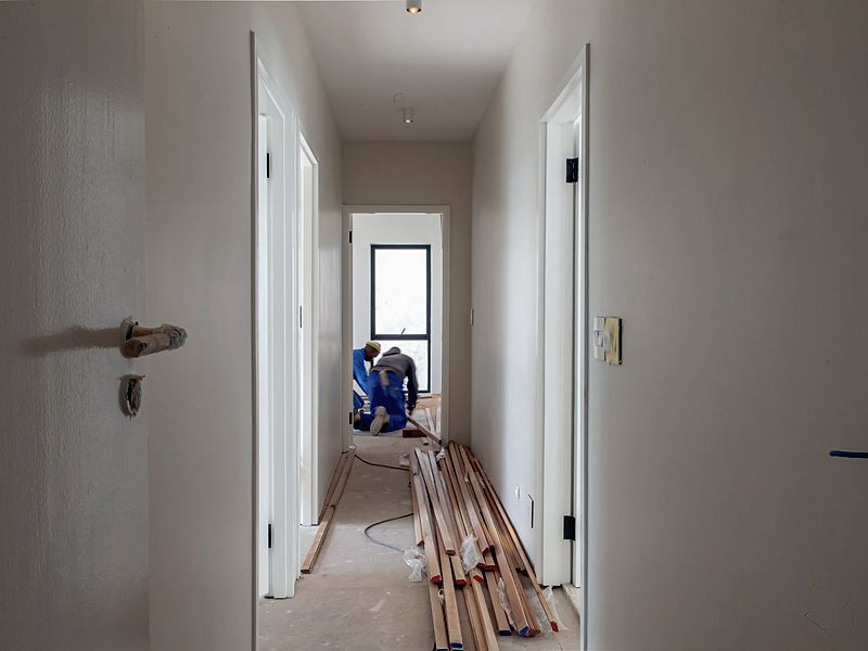 Interior renovation in progress with materials staged in a hallway