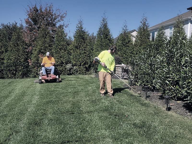 Grounds crew maintaining the lawn at a residential property