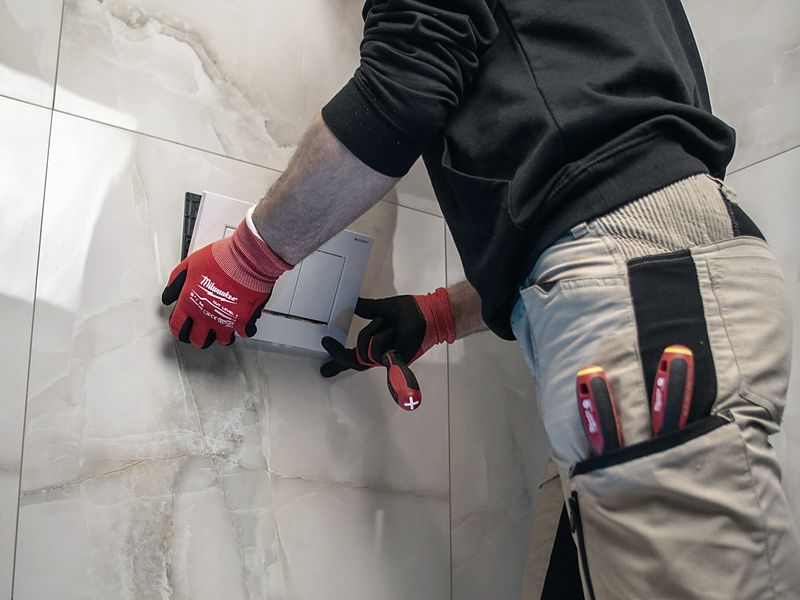 Tradesperson carrying out a bathroom plumbing repair
